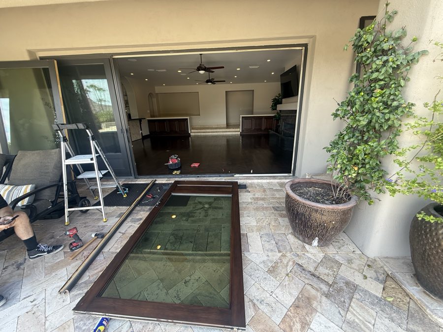 Wide sliding patio door opening with repair tools and a removed door panel