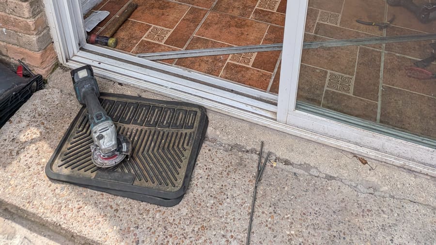 Sliding glass door panel removed from its lower track during repair