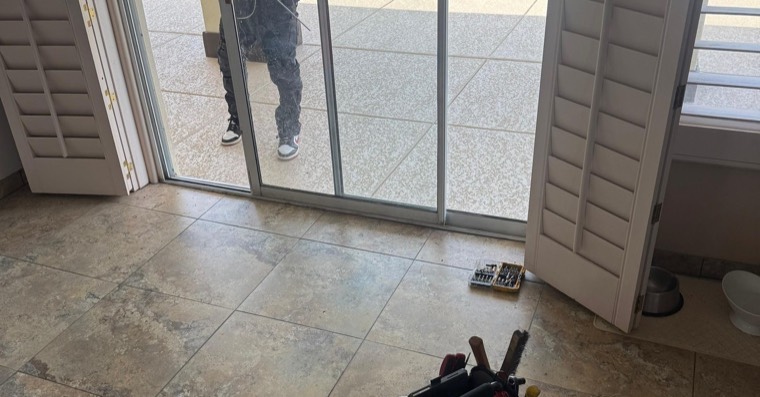 Technician tools near a sliding patio door handle area