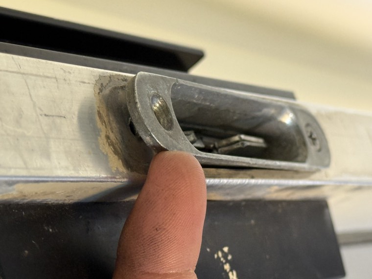 Close-up of a real sliding door latch and keeper area